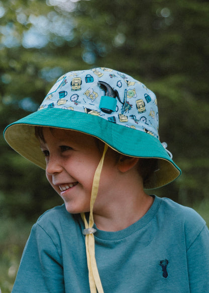 Young boy wearing a green bucket hat with a yellow chin strap