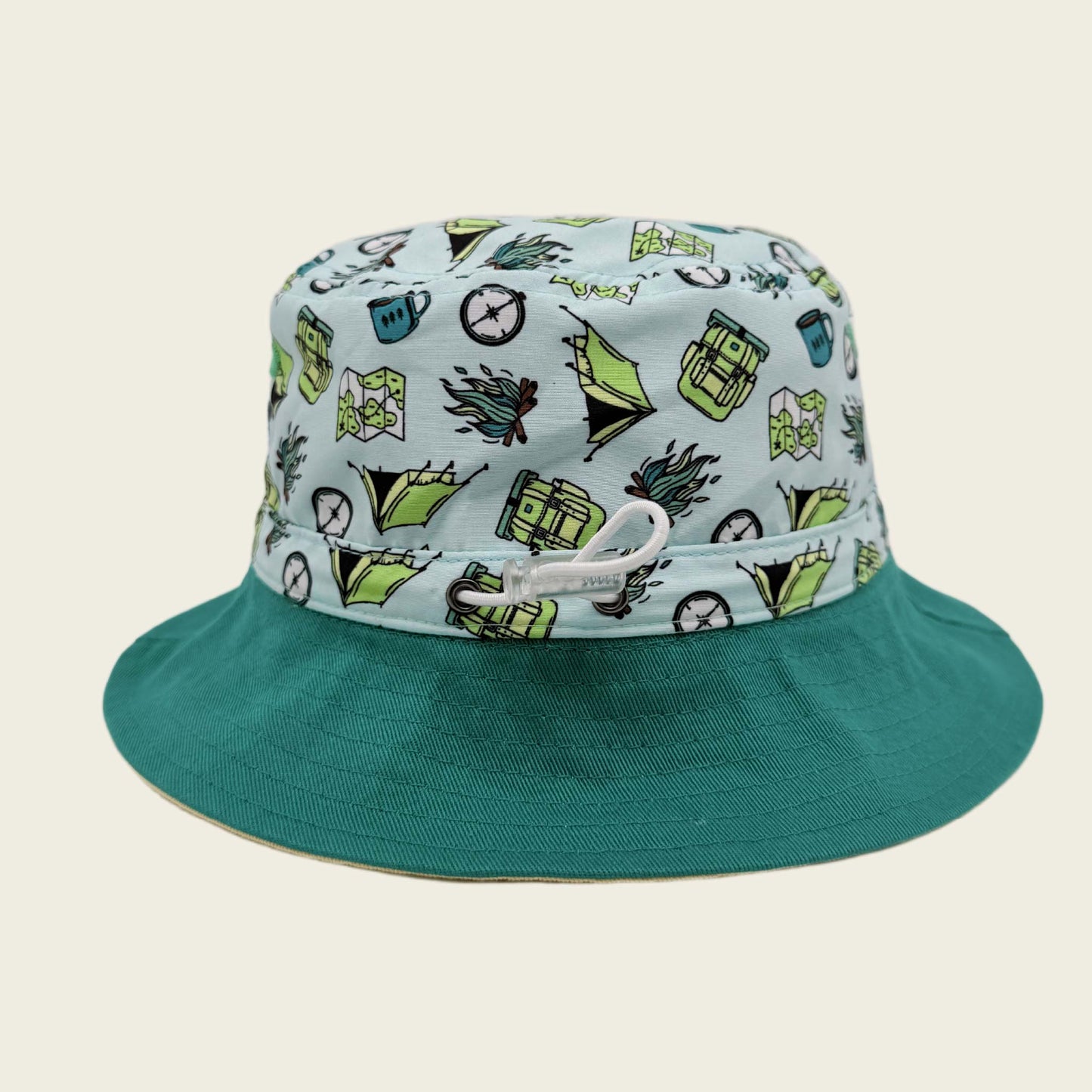 Bucket hat with a colorful pattern on the crown and solid green brim against a beige background