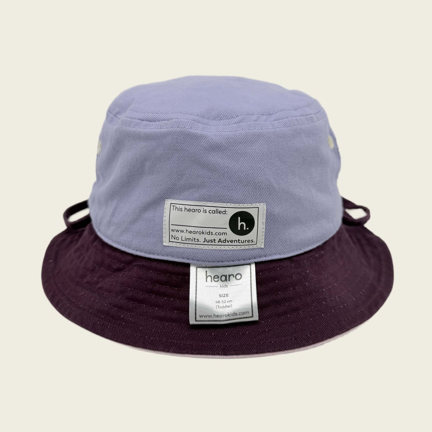 Two-tone bucket hat with visible name label on a beige background