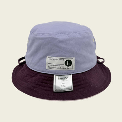 Two-tone bucket hat with visible name label on a beige background