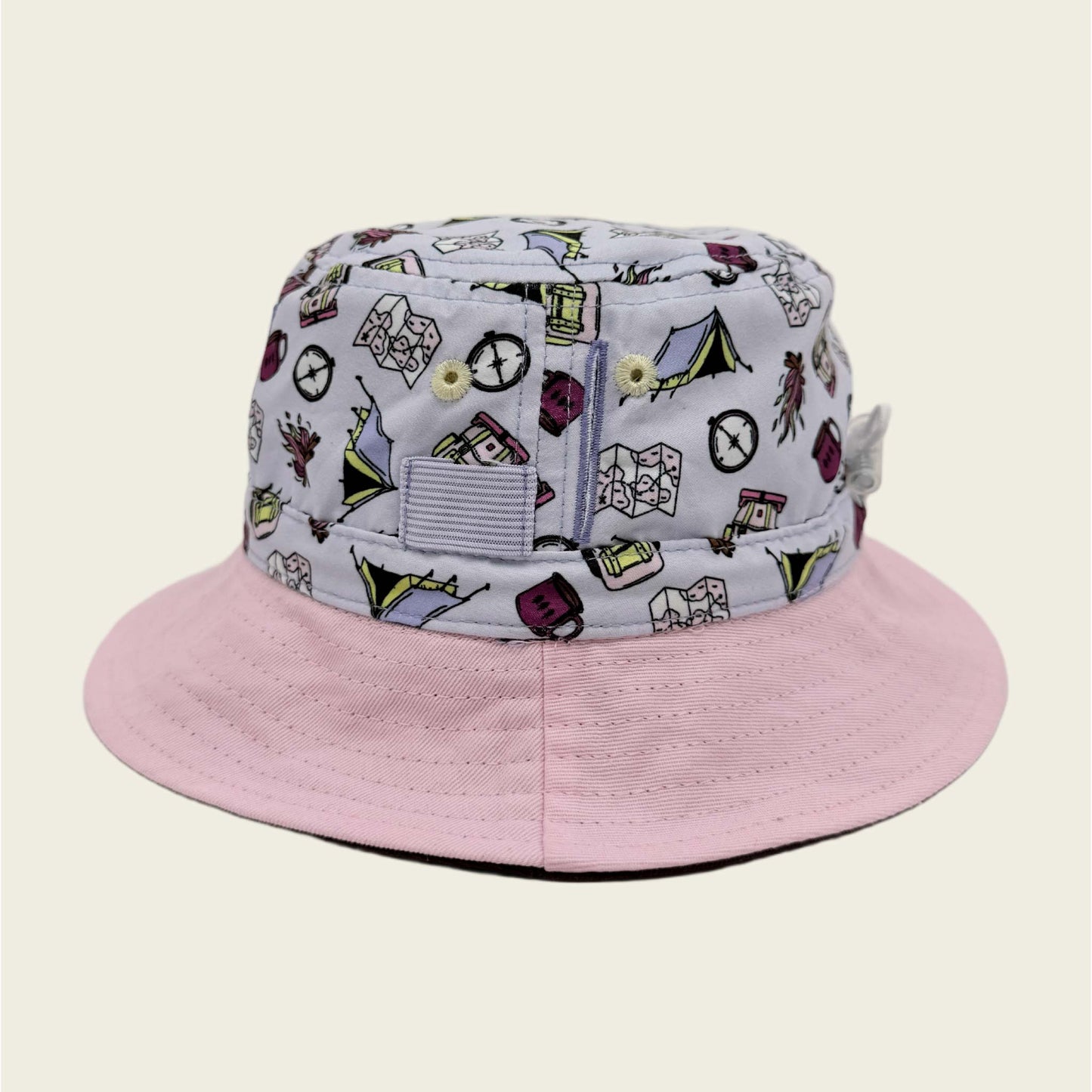 Pink bucket hat with a patterned brim on a beige background