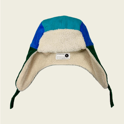 Color-blocked hat with fleece lining on a beige background
