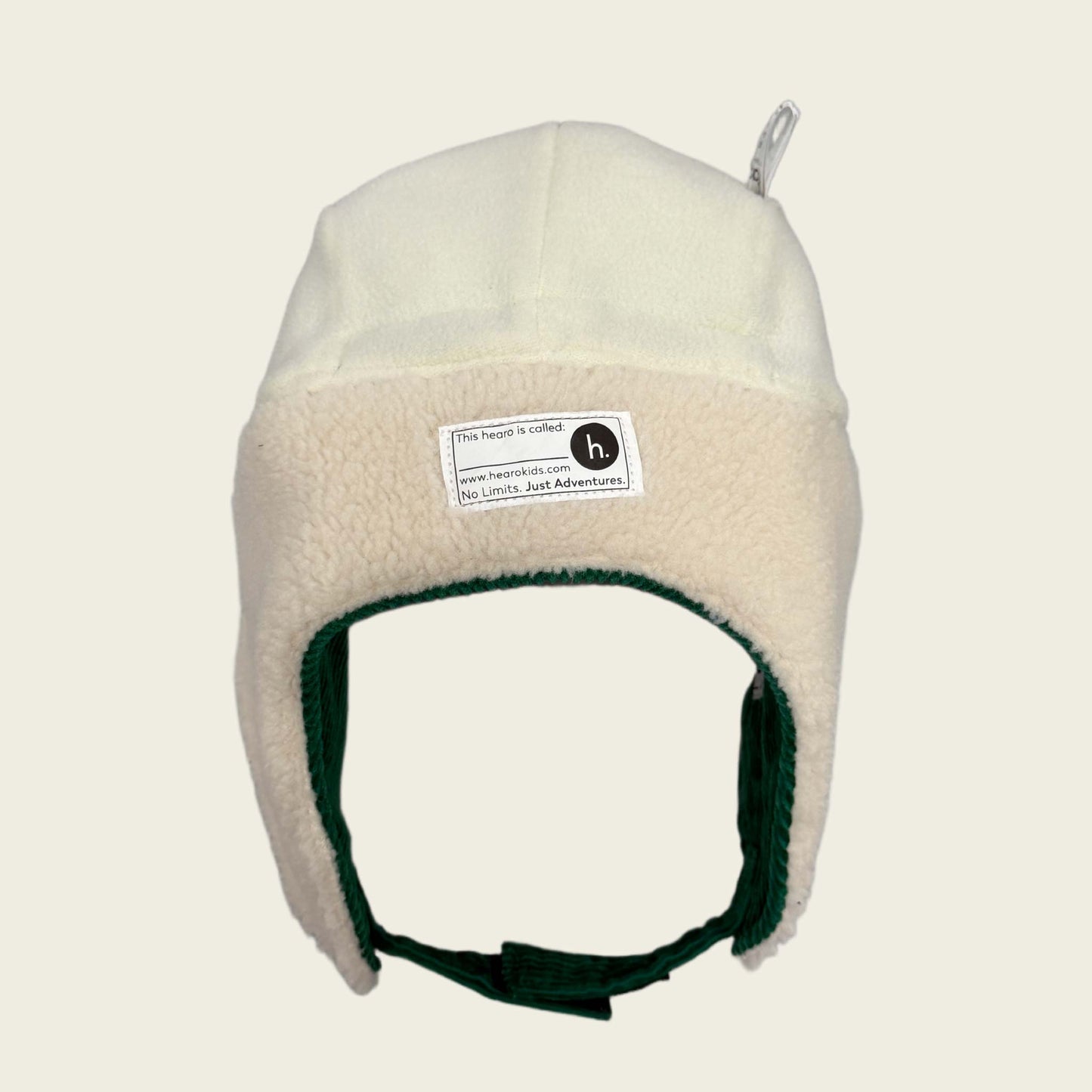 Beige fleece-lined winter hat with a name label on a beige background