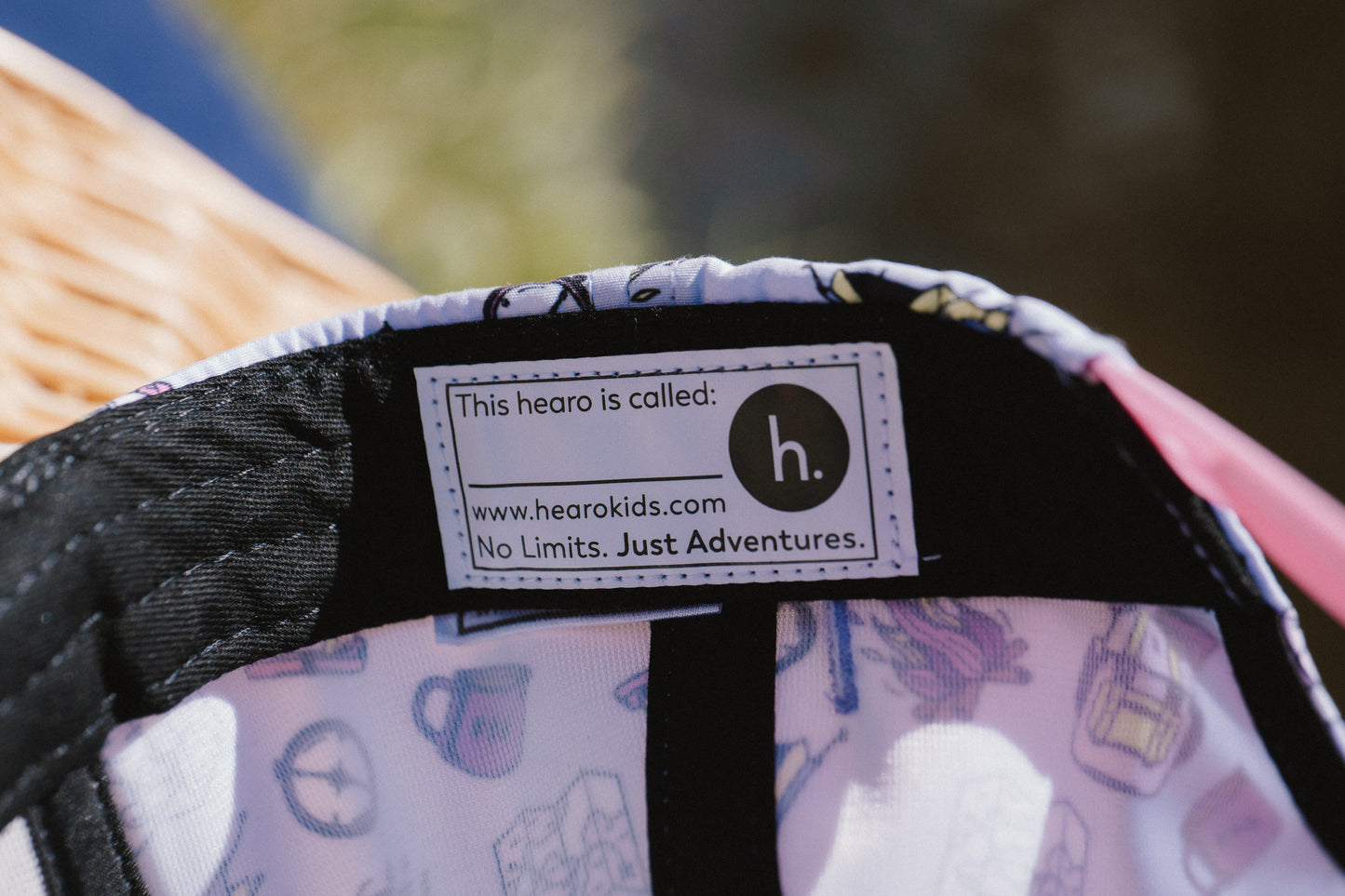 Close-up of the interior label of a children's hat or cap, showing the brand 'h.' and the website hearokids.