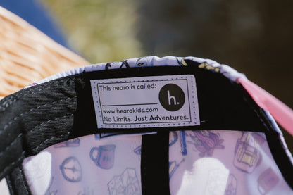 Close-up of the interior label of a children's hat or cap, showing the brand 'h.' and the website hearokids.