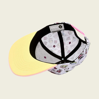 Snapback cap with yellow colored visor and black internal straps on a beige background